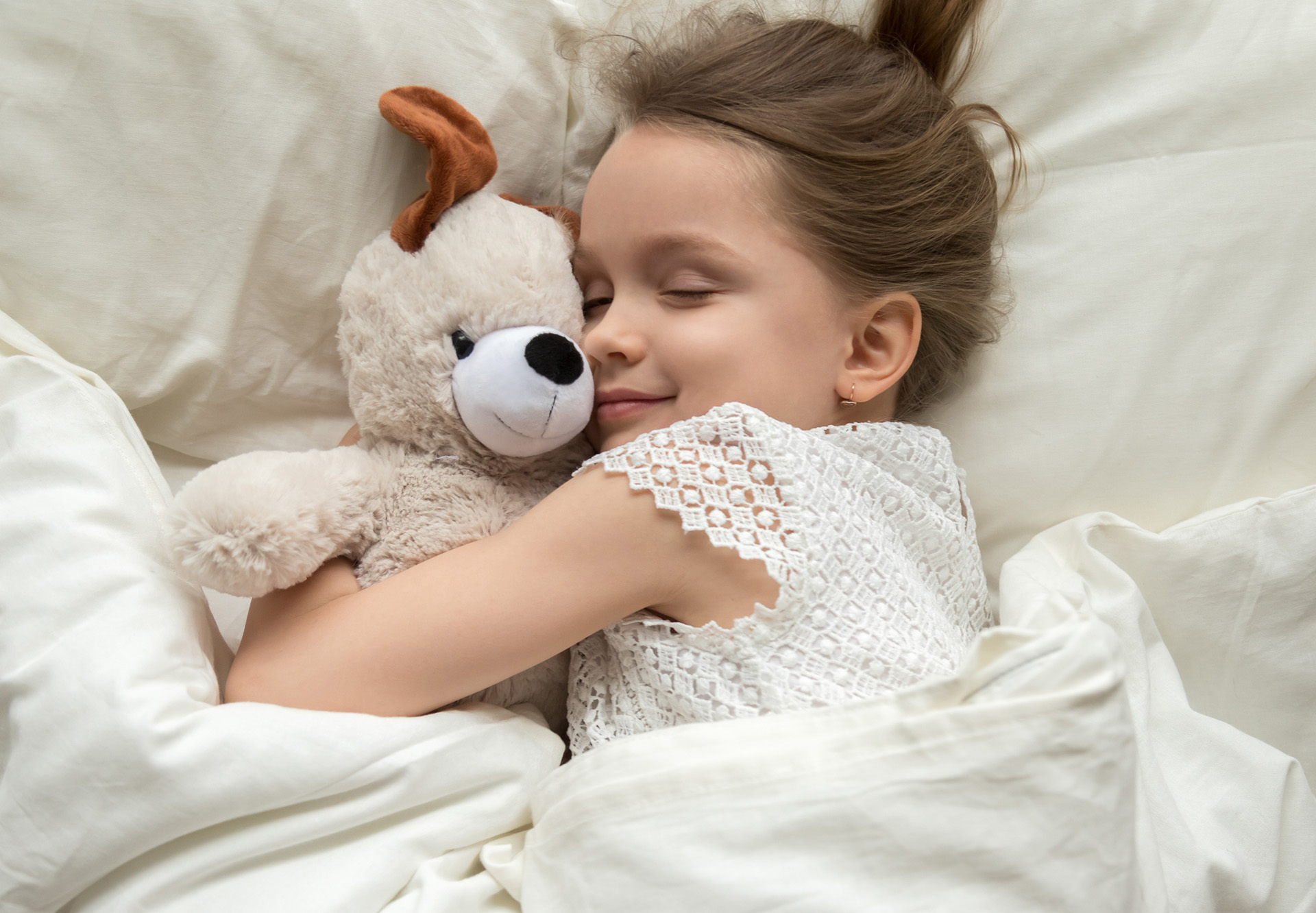 sleeping child hugging stuffed animal